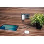 Verbatim Essentials Slim GaN-vægoplader på 65 W sidder i en stikkontakt med kabler tilsluttet og en tablet ved siden af.