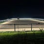 LEDlife LED-strip til ridebane lyser langs hegnet på en udendørs ridebane, hvor en rytter rider i mørket.