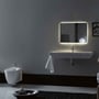 Lavabo Legacy 100 håndvask monteret på væg i et badeværelse, set forfra med spejl og synligt afløbsrør.