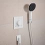 Hansgrohe Raindance Alive S håndbruser i mat hvid med grafit front, monteret på væg ved siden af termostat med Select-knap.