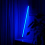 LEDlife 120 cm blå neonrør oplyser et rum med mørkeblå gardiner og en plante i forgrunden.