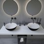 To Ideavit Solidthin-39 bordmonterede håndvaske i sort mineral komposit med hvid inderside, vist på en hvid bordplade.