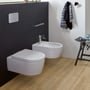 Villeroy & Boch ViConnect E200 betjeningsplade i krom monteret på en mørk badeværelsesvæg ved siden af et bidet.