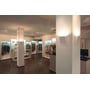 SLV Delma Wide LED-væglamper i hvid er monteret på søjler i en tøjbutik og lyser rummet op.