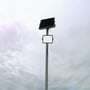 V-TAC 300W LED projektør og solpanel monteret på en høj stang, under en overskyet himmel for illustration af anvendelse.
