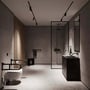 Sort Nichba toiletstøtte monteret ved siden af et toilet i et moderne badeværelse.