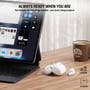Hvide 4smarts SkyBuds Air-øretelefoner og etuiet ligger ved en tablet og kaffekop på et bord.