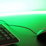 Komfortabel belysning med LEDlife grøn neon COB strip, der er monteret over en skrivepult med tastatur og mus.