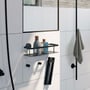 Smedbo xtra monteringsbeslag i sort mat monteret på en hvid badeværelsesvæg sammen med en hylde og en håndklædekrog.