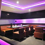 Restaurantinteriør med V-TAC RGB LED-strips langs lofter og vægge, der lyser i lilla nuancer.
