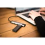 Verbatim Keypad Secure USB-drev ligger ved en USB-hub og bærbar computer på et træbord.
