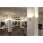 SLV Delma Wide LED-væglamper lyser op ad søjler i en tøjbutik med udstillede varer.