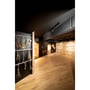 Helia 50 LED spot i hvid aluminium til 3-faset strømskinne, monteret i et rum med sort loft og trægulv.