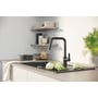 Grohe Quickfix Start køkkenarmatur i matsort med U-tud og udtrækssprinkler installeret i et moderne køkken ved siden af en vask.