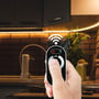 V-TAC touch-fjernbetjening bruges til at styre LED lysstrimler under et køkkenskab, hvilket viser nem anvendelse.