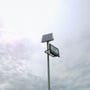V-TAC solpanel og LED projektør monteret på en mast mod en overskyet himmel.
