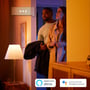 Philips Hue White E14 LED-kertepære lyser i en lampe i en stue, hvor beboere ankommer til varmt lys.