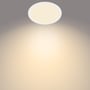 Philips myLiving Super Slim loftlampe i hvid, der lyser varmt hvidt lys op mod en mørk baggrund. Lampens slanke design er tydeligt.