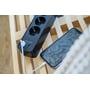 Nærbillede af Brennenstuhl Ecolor forlængerledning med USB-porte, hvor en telefon oplades via USB-kabel.