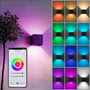 Flere LEDlife Cubic væglamper installeret på en facade, der lyser op med varierende RGB-farver og en demonstration af mobilapp-styring.