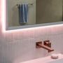 Hansgrohe Xarita E spejl 1000x700mm med LED-lys langs rammen, monteret over en mat kobberfarvet vandhane og lyserøde fliser.