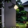 Sort V-TAC Pro solcellelampe monteret på en mur som væglampe, lysende udendørs i tusmørket.