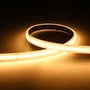 Ansell Lighting P-Cell LED strip på 10 meter, 24V, viser det varme hvide lys fra de mange små LED'er på en mørk, varm baggrund.