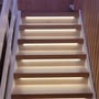 Detaljeret billede af en lige trappe med trin oplyst af LEDlife LED strips, der viser placeringen af lyset under forkanten af hvert trin.