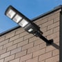 V-TAC VT-St180 LED solcelle gadelygte monteret på en murstensvæg mod en blå himmel.