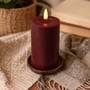 LEDlife bordeauxrødt bloklys med smelte-look og flammeeffekt, 12,5 cm høj, på en grå dug.