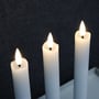 Close-up af tre LEDlife LED stearinlys med realistiske flammer, placeret på en grå bakke.