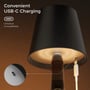 Undersiden af den sorte opladelige LED-flaskelampe viser USB-C-porten, mens lampen oplades med et kabel.
