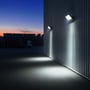 V-TAC LED-projektør på 100 W lyser op ad en lagerbygning og ud over gårdspladsen ved skumring.