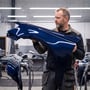 HICRI PRO-armaturer lyser i loftet i et værksted, hvor en mand undersøger en blå bildel.