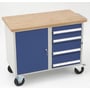 Værkstedsvogn VVM-1.1 fra Blika med blå skuffer og skab, multiplex bordplade og drejelige hjul, vist på hvid baggrund.