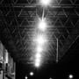 Flere V-TAC LED projektører lyser kraftigt op under en industriel stålkonstruktion om natten.