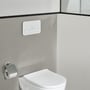 Viconnect M200-betjeningsplade i hvidt glas fra Villeroy & Boch monteret over et toilet på en grå væg.
