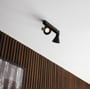 Nordlux Eik 2-spot spotlampe i sort metal monteret på et loft med træbeklædning.