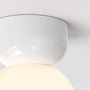 Astro Lighting Lyra loftlampe med nær visning af den blanke porcelænsfatning over den lysende skærm.