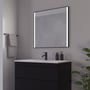 Loevschall Nyborg spejl, 80x75 cm, med sort ramme og to vertikale lysfelter foran et moderne badeværelsesmøbel.