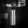 Cosmic Logic tandbørsteholder i børstet rustfrit stål med to tandbørster, monteret på mørk baggrund med en hylde i baggrunden.
