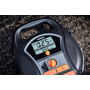 Osram TYREinflate 6000 dækoppumper set fra oven med det digitale display, der viser trykindstillinger, på en stenet baggrund.