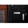 Kingston NV3 500 GB M.2 2280 SSD monteret i en bærbar computers bundkort ved siden af et værktøjssæt.