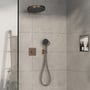 Hansgrohe ShowerSelect Comfort termostatbatteri i bronze monteret i et moderne badeværelsesmiljø med brusehoved og håndbruser.