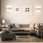 V-TAC LED-væglamper lyser op og ned på væggen i en indrettet stue.
