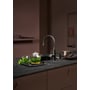 Quooker Flex Round-armatur i gunmetal monteret ved køkkenvask på mørk køkkenbordplade.