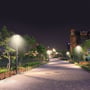 V-TAC LED havelamper monteret langs en brolagt sti i en park om natten, med blødt, jævnt lys.