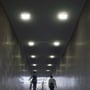 V-TAC 24W kvadratiske paneler installeret i en gangtunnell med lys murstensbeklædning, lyser op ad gangen.