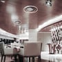 V-TAC loftlampen i et elegant hotel- eller receptionsmiljø med træbeklædning og siddeområder.
