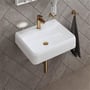 Duravit Push-open bundventil i børstet bronze monteret i en hvid håndvask, set ovenfra.